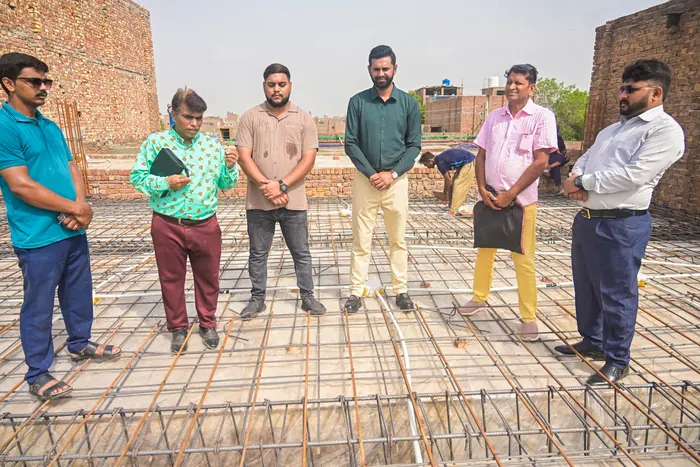 The team standing in prayer on the concrete roof as it was poured