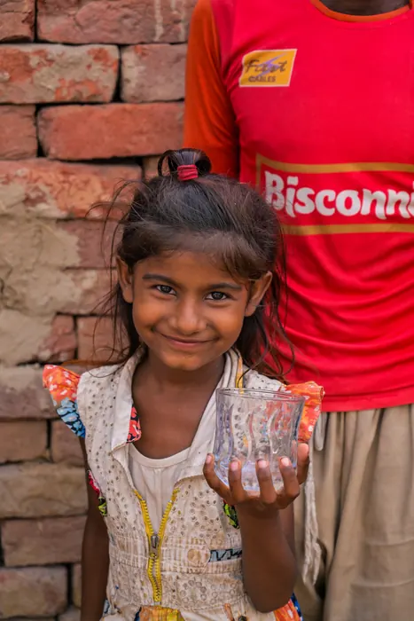 A girl holding a glass of clean, filtered water