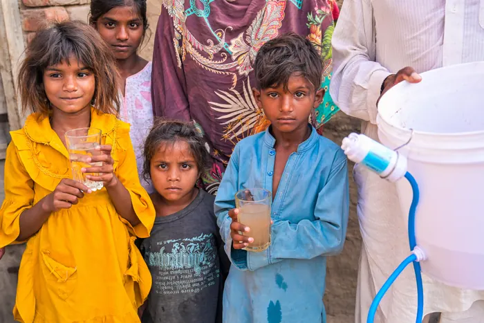 Children crowding round with their glasses after a filter was installed